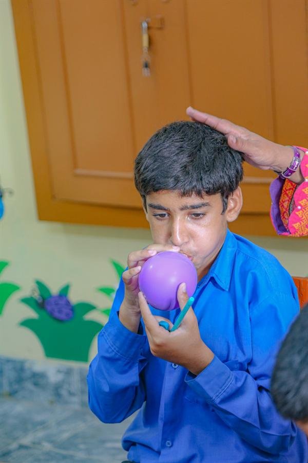 A student blowing up a purple balloon